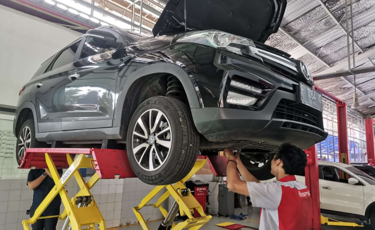 Mecánicos de DFSK Perú realizando la consulta técnica para el mantenimiento de autos