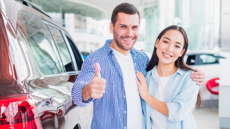 Pareja de personas felices en un concesionario de vehículos. 